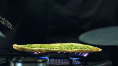 Şef, Pide Ekmeğini Gaz Tabağı 'na koyuyor. Yakın çekim yemek. Yemek pişirme süreci. Şef Aşçılık Tabağı. Şef yemek hazırlıyor. (Kızıl Ejder, Yavaş Hareket, Sinema Kaliteli Makro Görüntüler).