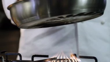Şef gaz ocağının tepsisini koydu. Yakın çekim yemek. Yemek pişirme süreci. Şef Aşçılık Tabağı. Şef yemek hazırlıyor. (Kızıl Ejder Kamerası, Yavaş Hareket, Sinema Kaliteli Makro Görüntüler).