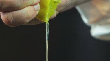 Şef limonu yavaş çekimde bir fincana sıkıştırıyor. Limon sıkmak, limon sıkmak. Şefin eli limon sıkıyor. Yakın çekim yiyecekler. Yemek pişirme süreci. Şef yemek hazırlıyor. (Kızıl Ejder Kamerası, Yavaş Hareket)