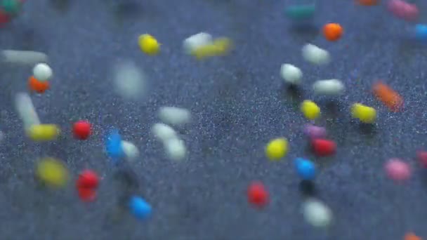 五彩斑斓的巨无霸灌满了甜糖糖的流动和封面镜头 下落和弹跳多种颜色的圆形颗粒 红龙相机慢动作镜头 — 图库视频影像