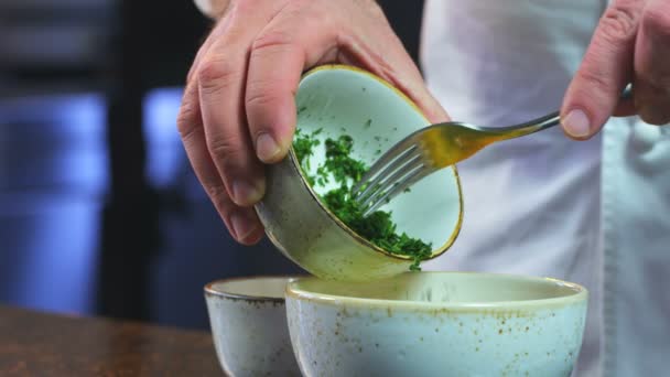 요리사가 잘게썬 야채를 접시에 넣는다 녹색을 음식을 클로즈업합니다 요리사 요리사가 — 비디오