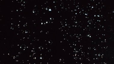 Yağmurlu pencerenin soyut koyu arkaplanı, siyah camlara yağmur damlaları