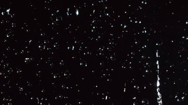 Yağmurlu pencerenin soyut koyu arkaplanı, siyah camlara yağmur damlaları