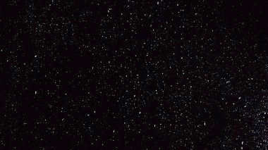 Yağmurlu pencerenin soyut koyu arkaplanı, siyah camlara yağmur damlaları