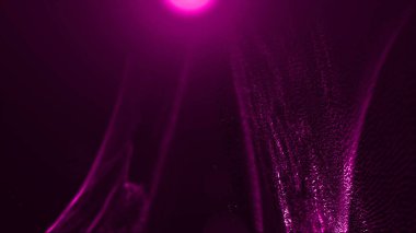 Parlayan parçacıkların olduğu soyut koyu arkaplan