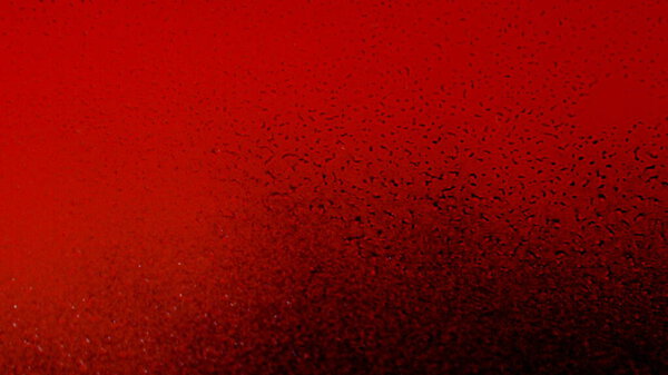 Paint ink red on glass window wall, shot on dark background.