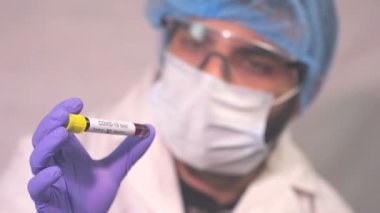 Doktor Coronavirus test tüpü, ncov kan testi gösteriyor. COVID-19 pozitif ve negatif test sonuçları. Doktor kan virüsü testi sonuçlarını gösteriyor. Kırmızı kamera yavaş çekim görüntüsü.