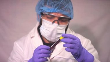 Doktor Coronavirus test tüpü, ncov kan testi gösteriyor. COVID-19 pozitif ve negatif test sonuçları. Doktor kan virüsü testi sonuçlarını gösteriyor. Kırmızı kamera yavaş çekim görüntüsü.