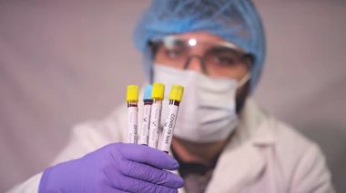 Doktor Coronavirus test tüpü, ncov kan testi gösteriyor. COVID-19 pozitif ve negatif test sonuçları. Doktor kan virüsü testi sonuçlarını gösteriyor. Kırmızı kamera yavaş çekim görüntüsü.
