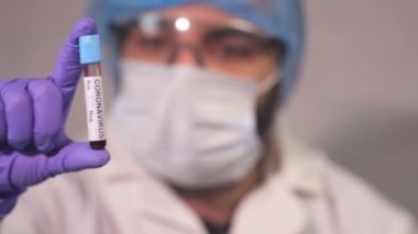 Doktor Coronavirus test tüpü, ncov kan testi gösteriyor. COVID-19 pozitif ve negatif test sonuçları. Doktor kan virüsü testi sonuçlarını gösteriyor. Kırmızı kamera yavaş çekim görüntüsü.