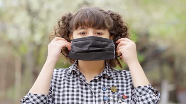 Küçük Kız Koronavirüs Salgını Sırasında Kameraya Bakarak Tıbbi Maske Takıyor — Stok video