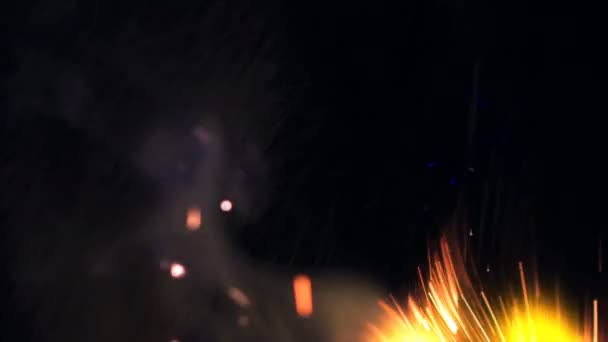 Images macro des étincelles de Bonfire. Les flammes de feu éclatent, les flammes de feu. Explosion micro scintille. Mini feux d'artifice. Tournage sur caméra rouge, ralenti sur fond noir. Belle étincelle de superposition de fuites .