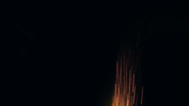 Bonfire kıvılcımlarının makro görüntüleri. Ateş patlar, ateş patlar. Patlama mikro parlaklığı. Mini Havai fişekler. Kırmızı kamerada çekim, siyah arka planda yavaş çekim. Güzel sızıntılar kıvılcım saçar.