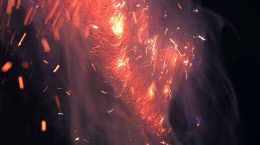 Şenlik ateşi kıvılcımlarının Macro fotoğrafı. Alevler patlar, patlamalar. Patlama mikro parlaklığı. Mini Havai fişekler. Kırmızı kamerada çekim hala siyah arkaplanda. Güzel sızıntılar kıvılcım posteri, afiş, duvar kağıdı, arkaplan, doku.