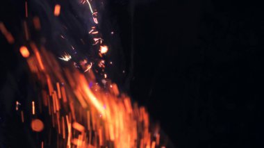 Şenlik ateşi kıvılcımlarının Macro fotoğrafı. Alevler patlar, patlamalar. Patlama mikro parlaklığı. Mini Havai fişekler. Kırmızı kamerada çekim hala siyah arkaplanda. Güzel sızıntılar kıvılcım posteri, afiş, duvar kağıdı, arkaplan, doku.