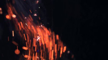 Şenlik ateşi kıvılcımlarının Macro fotoğrafı. Alevler patlar, patlamalar. Patlama mikro parlaklığı. Mini Havai fişekler. Kırmızı kamerada çekim hala siyah arkaplanda. Güzel sızıntılar kıvılcım posteri, afiş, duvar kağıdı, arkaplan, doku.