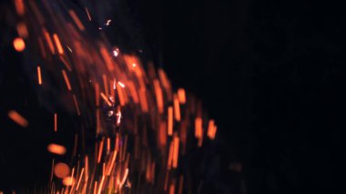 Şenlik ateşi kıvılcımlarının Macro fotoğrafı. Alevler patlar, patlamalar. Patlama mikro parlaklığı. Mini Havai fişekler. Kırmızı kamerada çekim hala siyah arkaplanda. Güzel sızıntılar kıvılcım posteri, afiş, duvar kağıdı, arkaplan, doku.