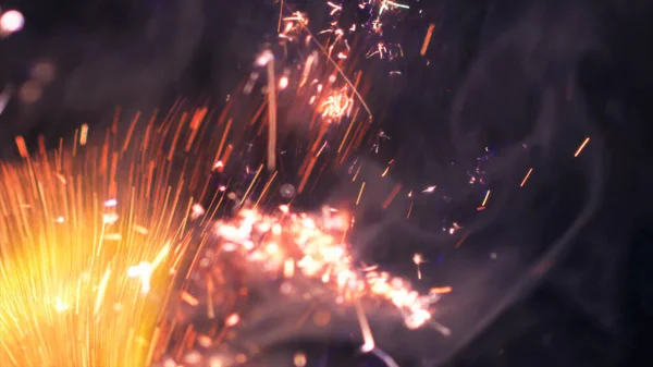 Macro photo of Bonfire sparks. Fire Flames bursts, blasts. Explosion micro sparkles. Mini Fireworks. Shooting on Red camera still on black background. Beautiful leaks overlay spark poster, banner, wallpaper, backdrop, texture.