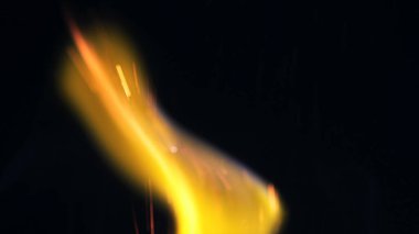 Şenlik ateşi kıvılcımlarının Macro fotoğrafı. Alevler patlar, patlamalar. Patlama mikro parlaklığı. Mini Havai fişekler. Kırmızı kamerada çekim hala siyah arkaplanda. Güzel sızıntılar kıvılcım posteri, afiş, duvar kağıdı, arkaplan, doku.