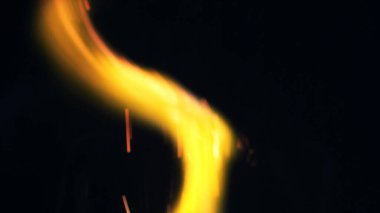 Şenlik ateşi kıvılcımlarının Macro fotoğrafı. Alevler patlar, patlamalar. Patlama mikro parlaklığı. Mini Havai fişekler. Kırmızı kamerada çekim hala siyah arkaplanda. Güzel sızıntılar kıvılcım posteri, afiş, duvar kağıdı, arkaplan, doku.