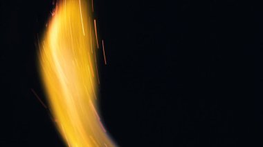 Şenlik ateşi kıvılcımlarının Macro fotoğrafı. Alevler patlar, patlamalar. Patlama mikro parlaklığı. Mini Havai fişekler. Kırmızı kamerada çekim hala siyah arkaplanda. Kıvılcım posteri, afiş, duvar kağıdı, doku.