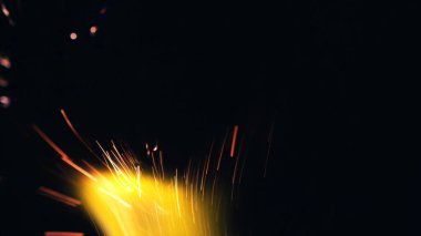 Şenlik ateşi kıvılcımlarının Macro fotoğrafı. Alevler patlar, patlamalar. Patlama mikro parlaklığı. Mini Havai fişekler. Kırmızı kamerada çekim hala siyah arkaplanda. Kıvılcım posteri, afiş, duvar kağıdı, doku.
