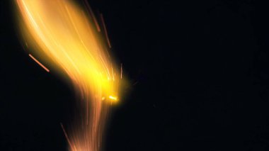 Şenlik ateşi kıvılcımlarının Macro fotoğrafı. Alevler patlar, patlamalar. Patlama mikro parlaklığı. Mini Havai fişekler. Kırmızı kamerada çekim hala siyah arkaplanda. Kıvılcım posteri, afiş, duvar kağıdı, doku.