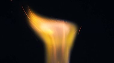 Şenlik ateşi kıvılcımlarının Macro fotoğrafı. Alevler patlar, patlamalar. Patlama mikro parlaklığı. Mini Havai fişekler. Kırmızı kamerada çekim hala siyah arkaplanda. Kıvılcım posteri, afiş, duvar kağıdı, doku.