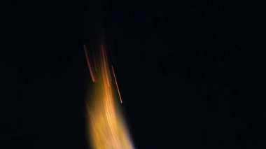 Şenlik ateşi kıvılcımlarının Macro fotoğrafı. Alevler patlar, patlamalar. Patlama mikro parlaklığı. Mini Havai fişekler. Kırmızı kamerada çekim hala siyah arkaplanda. Kıvılcım posteri, afiş, duvar kağıdı, doku.