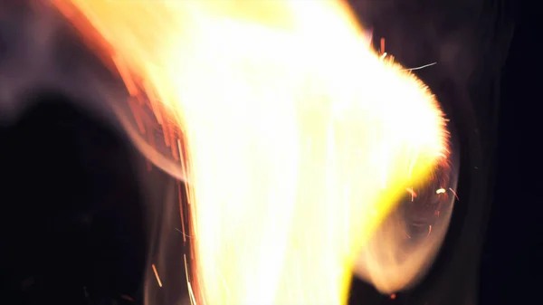 Macro photo of Bonfire sparks. Fire Flames bursts, blasts. Explosion micro sparkles. Mini Fireworks. Shooting on Red camera still on black background. Beautiful leaks overlay spark poster, banner, wallpaper, backdrop, texture.