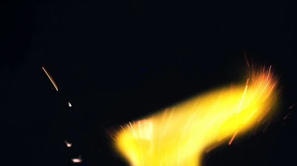 篝火火花的宏观照片 火焰熊熊燃烧 爆炸的微小火花 迷你烟花 在红色相机上拍摄仍然在黑色背景 — 图库照片