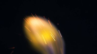 Şenlik ateşi kıvılcımlarının Macro fotoğrafı. Alevler patlar, patlamalar. Patlama mikro parlaklığı. Mini Havai fişekler. Kırmızı kamerada çekim hala siyah arkaplanda. Kıvılcım posteri, afiş, duvar kağıdı, doku.