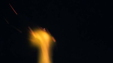 Şenlik ateşi kıvılcımlarının Macro fotoğrafı. Alevler patlar, patlamalar. Patlama mikro parlaklığı. Mini Havai fişekler. Kırmızı kamerada çekim hala siyah arkaplanda. Kıvılcım posteri, afiş, duvar kağıdı, doku.