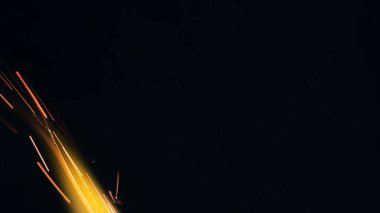 Şenlik ateşi kıvılcımlarının Macro fotoğrafı. Alevler patlar, patlamalar. Patlama mikro parlaklığı. Mini Havai fişekler. Kırmızı kamerada çekim hala siyah arkaplanda. Kıvılcım posteri, afiş, duvar kağıdı, doku.