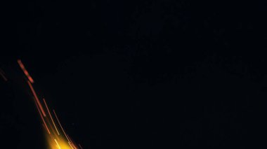 Şenlik ateşi kıvılcımlarının Macro fotoğrafı. Alevler patlar, patlamalar. Patlama mikro parlaklığı. Mini Havai fişekler. Kırmızı kamerada çekim hala siyah arkaplanda. Kıvılcım posteri, afiş, duvar kağıdı, doku.