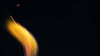 Şenlik ateşi kıvılcımlarının Macro fotoğrafı. Alevler patlar, patlamalar. Patlama mikro parlaklığı. Mini Havai fişekler. Kırmızı kamerada çekim hala siyah arkaplanda. Kıvılcım posteri, afiş, duvar kağıdı, doku.