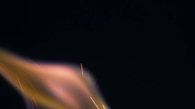 Şenlik ateşi kıvılcımlarının Macro fotoğrafı. Alevler patlar, patlamalar. Patlama mikro parlaklığı. Mini Havai fişekler. Kırmızı kamerada çekim hala siyah arkaplanda. Kıvılcım posteri, afiş, duvar kağıdı, doku.