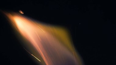 Şenlik ateşi kıvılcımlarının Macro fotoğrafı. Alevler patlar, patlamalar. Patlama mikro parlaklığı. Mini Havai fişekler. Kırmızı kamerada çekim hala siyah arkaplanda. Kıvılcım posteri, afiş, duvar kağıdı, doku.