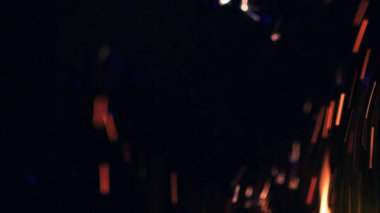 Şenlik ateşi kıvılcımlarının Macro fotoğrafı. Alevler patlar, patlamalar. Patlama mikro parlaklığı. Mini Havai fişekler. Kırmızı kamerada çekim hala siyah arkaplanda. Güzel sızıntılar kıvılcım posteri, afiş, duvar kağıdı, arkaplan, doku.