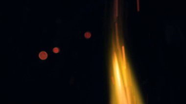 Şenlik ateşi kıvılcımlarının Macro fotoğrafı. Alevler patlar, patlamalar. Patlama mikro parlaklığı. Mini Havai fişekler. Kırmızı kamerada çekim hala siyah arkaplanda. Güzel sızıntılar kıvılcım posteri, afiş, duvar kağıdı, arkaplan, doku.