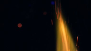 Şenlik ateşi kıvılcımlarının Macro fotoğrafı. Alevler patlar, patlamalar. Patlama mikro parlaklığı. Mini Havai fişekler. Kırmızı kamerada çekim hala siyah arkaplanda. Güzel sızıntılar kıvılcım posteri, afiş, duvar kağıdı, arkaplan, doku.