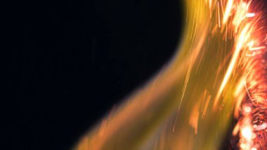 Şenlik ateşi kıvılcımlarının Macro fotoğrafı. Alevler patlar, patlamalar. Patlama mikro parlaklığı. Mini Havai fişekler. Kırmızı kamerada çekim hala siyah arkaplanda. Güzel sızıntılar kıvılcım posteri, afiş, duvar kağıdı, arkaplan, doku.