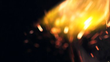 Şenlik ateşi kıvılcımlarının Macro fotoğrafı. Alevler patlar, patlamalar. Patlama mikro parlaklığı. Mini Havai fişekler. Kırmızı kamerada çekim hala siyah arkaplanda. Güzel sızıntılar kıvılcım posteri, afiş, duvar kağıdı, arkaplan, doku.