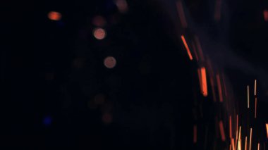 Şenlik ateşi kıvılcımlarının Macro fotoğrafı. Alevler patlar, patlamalar. Patlama mikro parlaklığı. Mini Havai fişekler. Kırmızı kamerada çekim hala siyah arkaplanda. Güzel sızıntılar kıvılcım posteri, afiş, duvar kağıdı, arkaplan, doku.