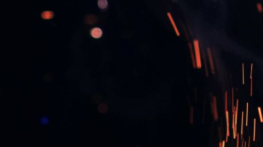Şenlik ateşi kıvılcımlarının Macro fotoğrafı. Alevler patlar, patlamalar. Patlama mikro parlaklığı. Mini Havai fişekler. Kırmızı kamerada çekim hala siyah arkaplanda. Güzel sızıntılar kıvılcım posteri, afiş, duvar kağıdı, arkaplan, doku.