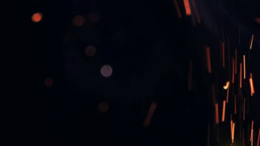Şenlik ateşi kıvılcımlarının Macro fotoğrafı. Alevler patlar, patlamalar. Patlama mikro parlaklığı. Mini Havai fişekler. Kırmızı kamerada çekim hala siyah arkaplanda. Güzel sızıntılar kıvılcım posteri, afiş, duvar kağıdı, arkaplan, doku.