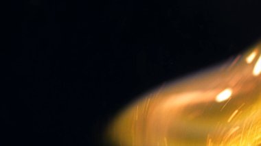 Şenlik ateşi kıvılcımlarının Macro fotoğrafı. Alevler patlar, patlamalar. Patlama mikro parlaklığı. Mini Havai fişekler. Kırmızı kamerada çekim hala siyah arkaplanda. Güzel sızıntılar kıvılcım posteri, afiş, duvar kağıdı, arkaplan, doku.