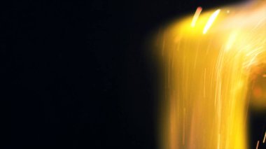 Şenlik ateşi kıvılcımlarının Macro fotoğrafı. Alevler patlar, patlamalar. Patlama mikro parlaklığı. Mini Havai fişekler. Kırmızı kamerada çekim hala siyah arkaplanda. Güzel sızıntılar kıvılcım posteri, afiş, duvar kağıdı, arkaplan, doku.