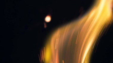 Şenlik ateşi kıvılcımlarının Macro fotoğrafı. Alevler patlar, patlamalar. Patlama mikro parlaklığı. Mini Havai fişekler. Kırmızı kamerada çekim hala siyah arkaplanda. Güzel sızıntılar kıvılcım posteri, afiş, duvar kağıdı, arkaplan, doku.