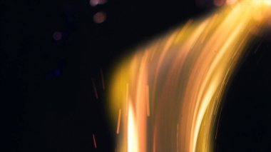 Şenlik ateşi kıvılcımlarının Macro fotoğrafı. Alevler patlar, patlamalar. Patlama mikro parlaklığı. Mini Havai fişekler. Kırmızı kamerada çekim hala siyah arkaplanda. Güzel sızıntılar kıvılcım posteri, afiş, duvar kağıdı, arkaplan, doku.